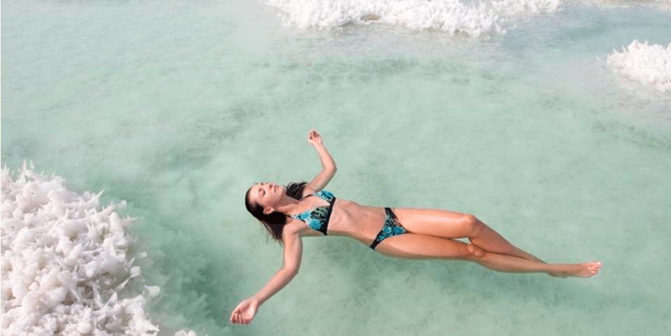 mujer flotando en el mar muerto de jordania