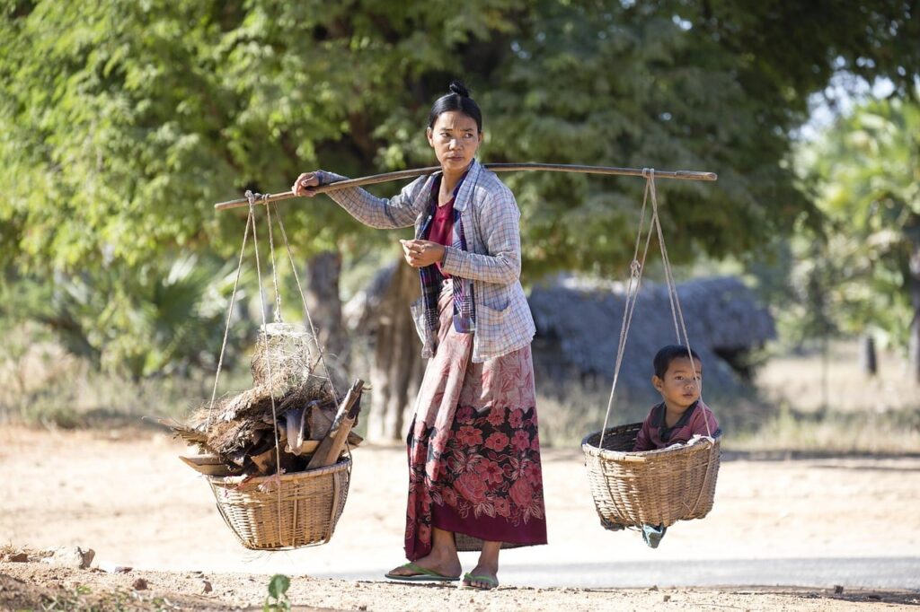 mujer en Myanmar llevando a su niño en una cesta