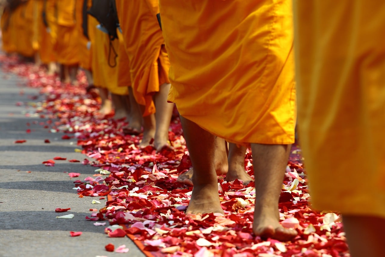 monjes caminando sobre flores en Tailandia