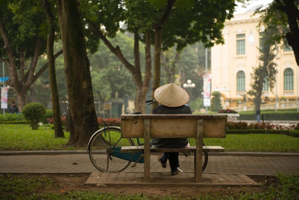 mujer con bicicleta descansando en ciudad de Vietnam